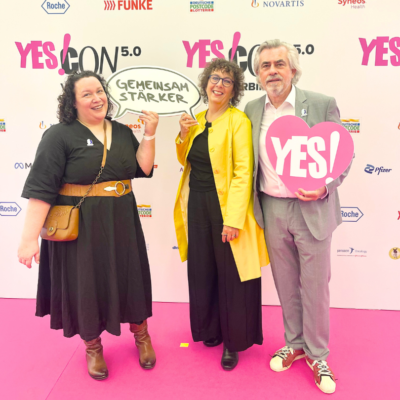 Carmen Dreyer, Judith Grümmer und Thomas Koenen auf dem pinken Teppich bei der Yes!Con