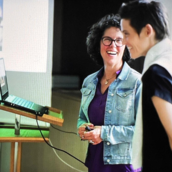 Audiobiografin im Hintergrund. Im vordergrund eine Projektteilnehmerin. Beide lachen.